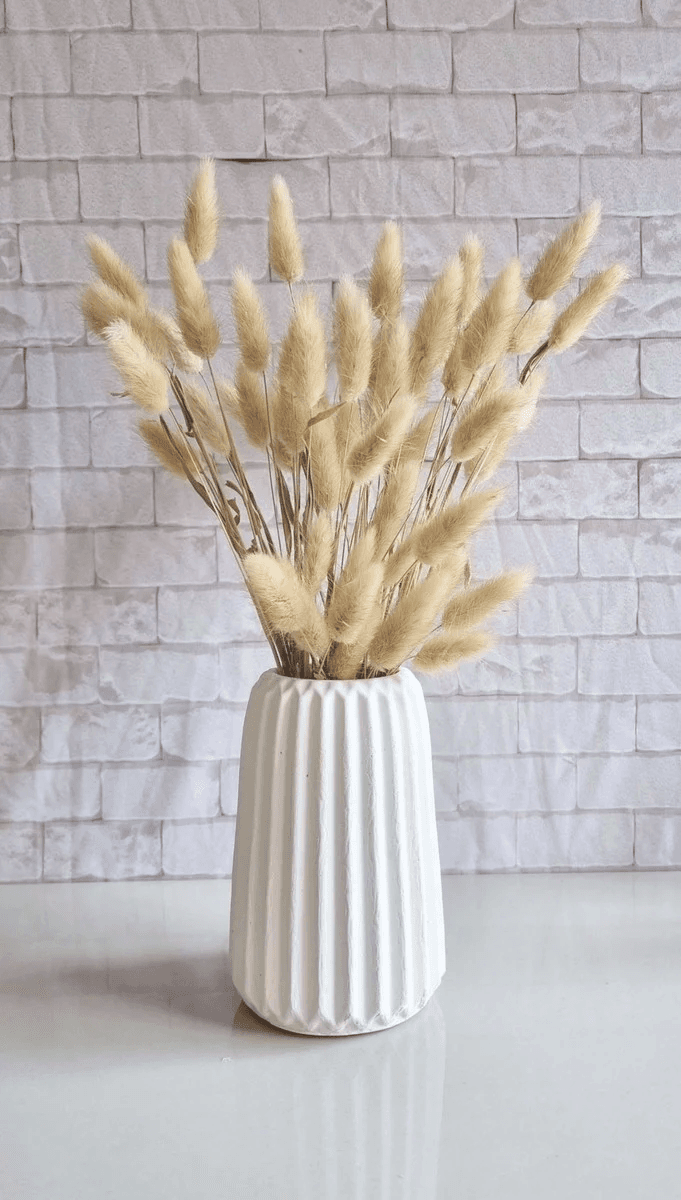 Imagem de um vaso de concreto branco com textura canelada vertical