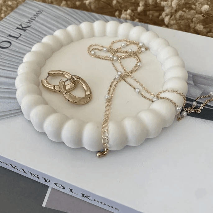 Imagem de uma bandeja de concreto branca com uma borda estilizada